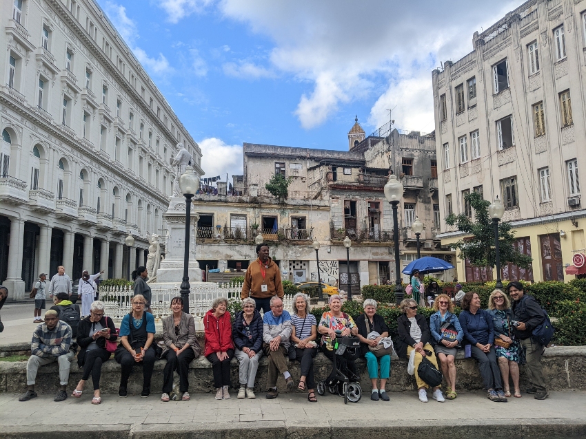 Tour group in Cuba with dilapidated and new buildings in the background